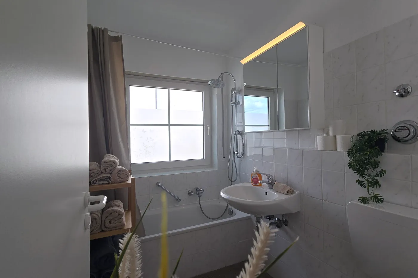 Gepflegtes Bad mit Badewanne und frischen Handtüchern